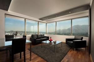 a living room filled with furniture and large windows at Boulevard Suites Ferrat in Santiago