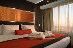 1 dormitorio con 1 cama grande y ventana grande en Boulevard Suites Ferrat, en Santiago
