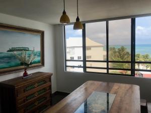 a dining room with a table and a large window at Penthouse San Andres Isla in San Andrés