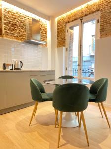 - une cuisine et une salle à manger avec une table et des chaises dans l'établissement Apartamentos con encanto en La Latina, à Madrid