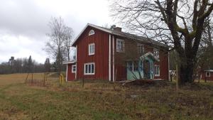 czerwony dom siedzący na polu w obiekcie Wallas i Hylte 4, SÄVSJÖ LAMMHULT w mieście Lammhult