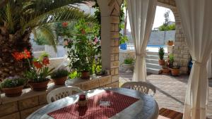 a patio with a table and chairs and plants at Villa Mateja in Novalja