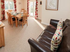 uma sala de estar com um sofá de couro e uma mesa em The Laurels em Haverfordwest