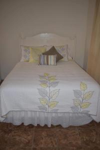 a bed with a white blanket and pillows on it at Villa Vicente in Vila Nova Sintra