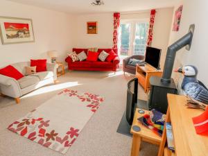 a living room with a red couch and a bird on a table at The Laurels in Haverfordwest