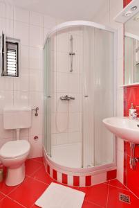 a bathroom with a shower and a toilet and a sink at Apartments Makarska Gudelj Cvitan in Makarska +126 photos