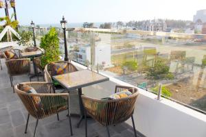 un balcone con tavoli, sedie e una grande finestra di EMERALD OCEAN HOTEL a Phan Thiet