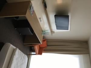 Kleines Zimmer mit einem TV und einem kleinen Schrank. in der Unterkunft Ardey Hotel in Witten