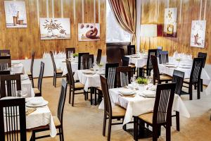a restaurant with tables and chairs with white tablecloths at B09 Mauritius - Silver Mountain in Poiana Brasov