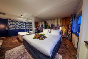 een slaapkamer met een groot bed en een badkamer bij Hotel Haarhuis in Arnhem