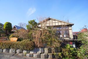 ein Haus auf einer Steinmauer in der Unterkunft Yufunoyado Kifu in Yufu