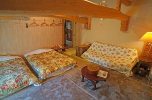 Cette chambre comprend deux lits, une table et un canapé. dans l'établissement Yufunoyado Kifu, à Yufu
