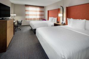 a hotel room with two beds and a flat screen tv at La Quinta by Wyndham LAX in Los Angeles