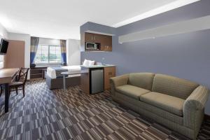 a hotel room with a couch and a table and a kitchen at Microtel Inn Suite by Wyndham BWI Airport in Linthicum Heights