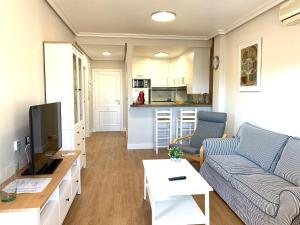 a living room with a couch and a tv at Aldeas De Aguamarina Cabo Roig in Orihuela Costa