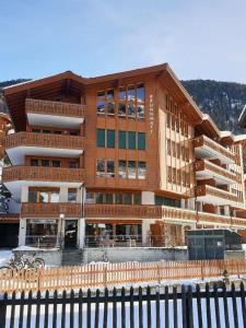 a large building with a fence in front of it at Studio Brunnmatt in Zermatt