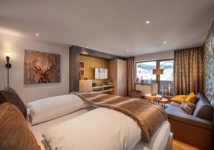 a bedroom with a large bed and a living room at Bayern Resort Hotel - Adults only - mit Zugspitzblick - Eibsee-Nähe - Wellnessbereich - Naturpool im Sommer in Grainau