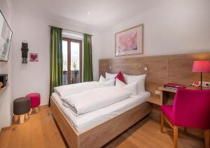 a bedroom with a large bed with a desk and a bed sidx sidx sidx sidx at Bayern Resort Hotel - Adults only - mit Zugspitzblick - Eibsee-Nähe - Wellnessbereich - Naturpool im Sommer in Grainau