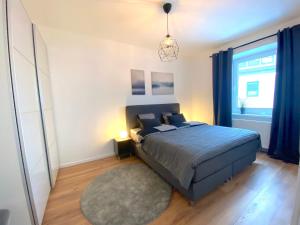 a bedroom with a bed and a large window at White Inn - Kuschelige Ferienwohnung in Mürzzuschlag