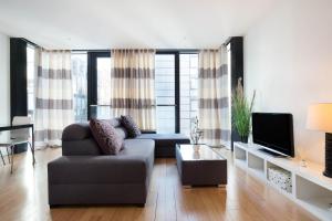 a living room with a couch and a tv at Quartermile Central Apartment in Edinburgh