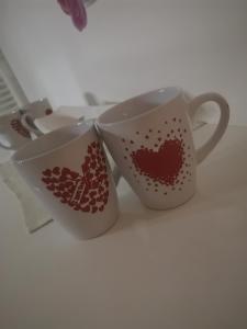 two cups with hearts on them sitting on a table at Sweet Dreams Apartment in Varaždin