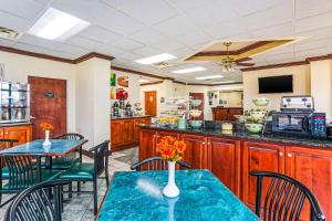 a kitchen with a table, chairs and a refrigerator at Quality Inn Russellville in Russellville