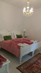 - un lit blanc dans une chambre dotée d'un lustre dans l'établissement NN Deluxe room near Athens airport, à Spáta