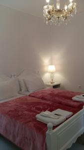 - une chambre avec un lit doté d'une couverture rouge et d'un lustre dans l'établissement NN Deluxe room near Athens airport, à Spáta
