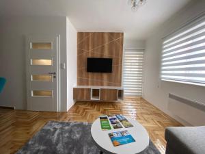 a living room with a table and a tv at Apartman Una in Pale