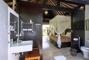 a bathroom with a sink and a bed in a room at Lodtunduh Sari in Ubud +59 photos