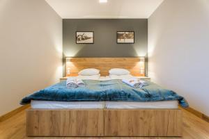 a bedroom with a large bed with two pillows at Hotel***Gorce in Nowy Targ