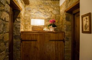 una lampada sopra una porta di legno in un muro di pietra di B&B Lavanda e Rosmarino a Capolona