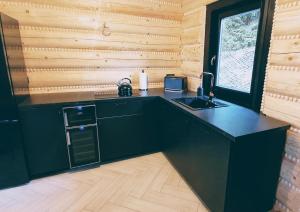 a kitchen with a black counter and a sink at Koniakowo - dom Hunter in Koniaków +23 photos