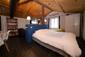 Un dormitorio con una cama grande en una habitación con techos de madera. en Au Passage du Gois en Beauvoir-sur-Mer