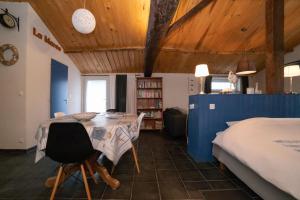 Habitación con cama, mesa y sillas. en Au Passage du Gois en Beauvoir-sur-Mer