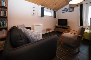 sala de estar con sofá y TV en Au Passage du Gois en Beauvoir-sur-Mer