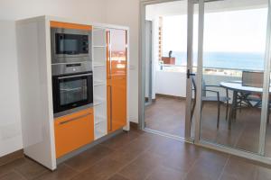 a kitchen with an orange cabinet and a table with a view at LE TERRAZZE 6 in Puerto de la Cruz