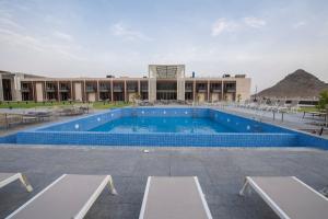 
a large swimming pool in a large building at استراحة الفيحاء AL Feyhaa Resthouse in Samail
