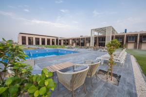 un resort con piscina, sedie e un edificio di استراحة الفيحاء AL Feyhaa Resthouse a Fujayrah