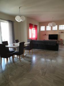 a living room with a couch and a table and chairs at Maria's Sharing Apartment in Heraklio