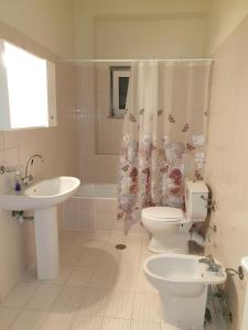 a bathroom with a sink and a toilet and a shower curtain at Maria's Sharing Apartment in Heraklio +25 photos