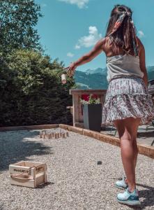 een vrouw in een rok die met stenen speelt bij La Ferme du Golf in Megève