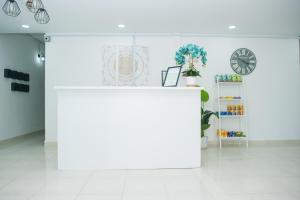 a white room with a counter and a clock at IBAI BEACH GUESTHOUSE in Kuala Terengganu