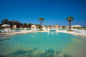 duży basen z krzesłami i palmami w obiekcie Garda Residence San Vigilio Golf w mieście Pozzolengo