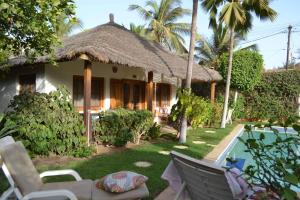 a villa with a swimming pool and a house at Jardin d'Afrique in Saly Portudal