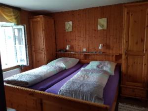 łóżko w pokoju z drewnianymi ścianami w obiekcie Ferien auf dem Bermeshof w mieście Preischeid