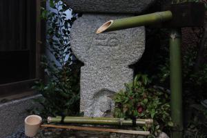 un poteau vert assis à côté d'un mur de pierre dans l'établissement Guesthouse Higashiyama Jao, à Kyoto