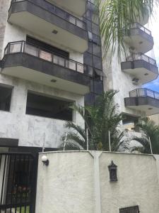 een gebouw met balkons en een palmboom ervoor bij Apartamento CF BRAGA in Cabo Frio