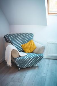 a couch with polka dot pillows on it in a room at Bieszczadzki Hals - Dom bliźniak in Polańczyk