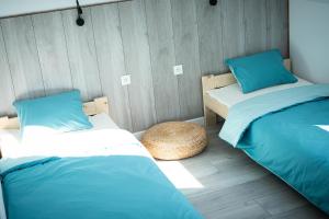 two beds in a room with blue and white at Bieszczadzki Hals - Dom bliźniak in Polańczyk